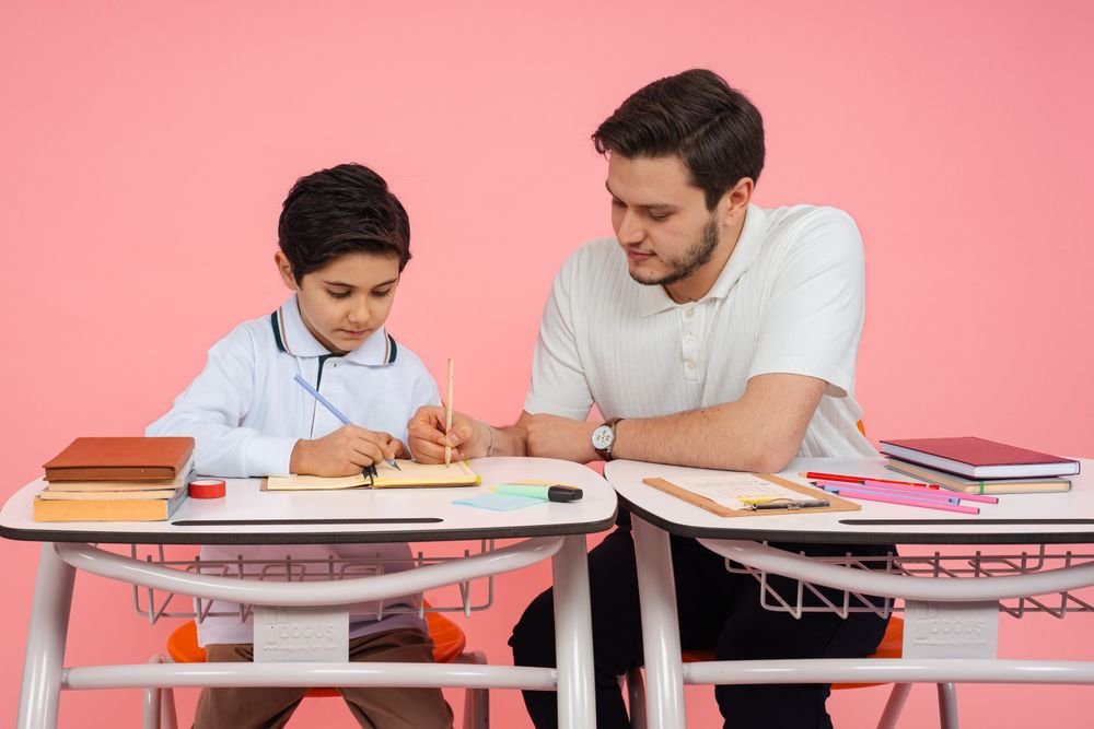 A teacher helping a student at a desk