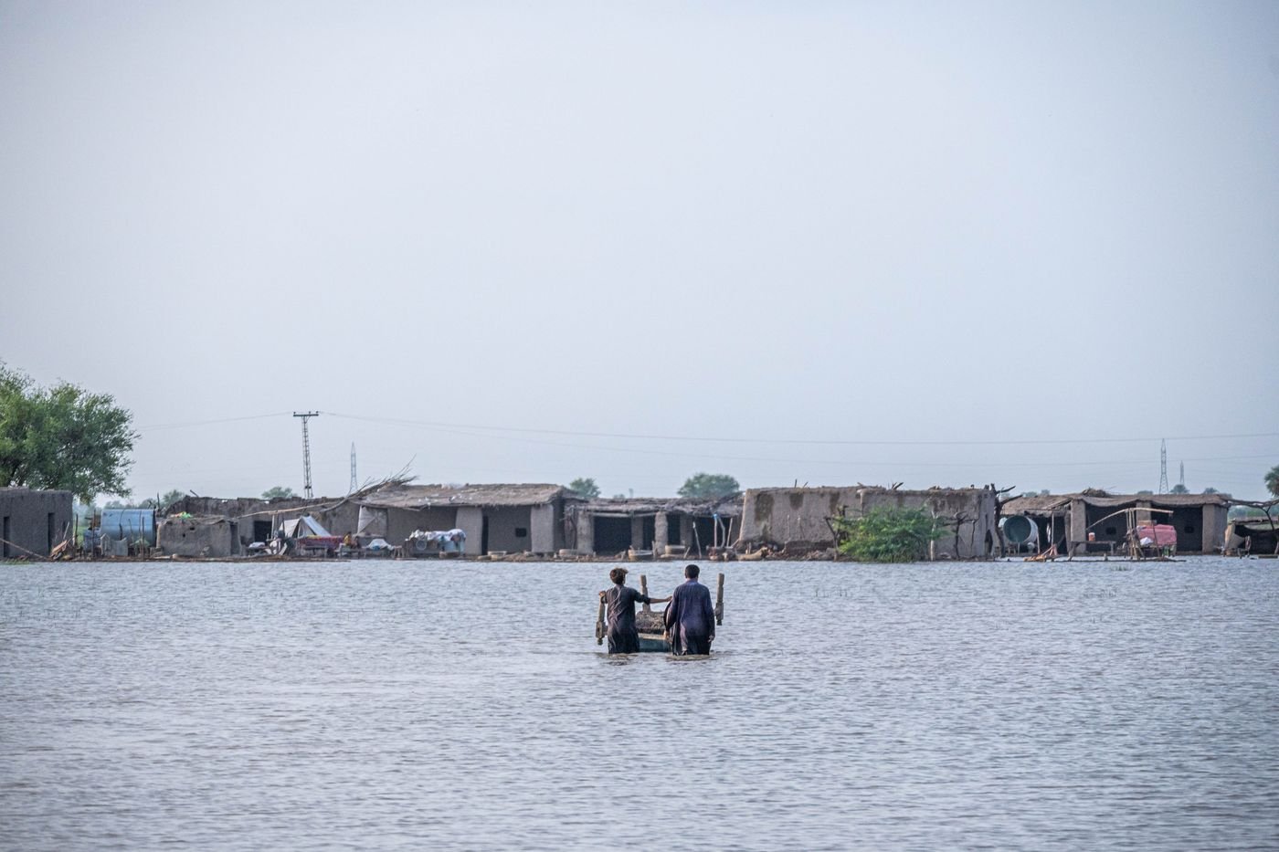 People wading through floodwater in Pakistan