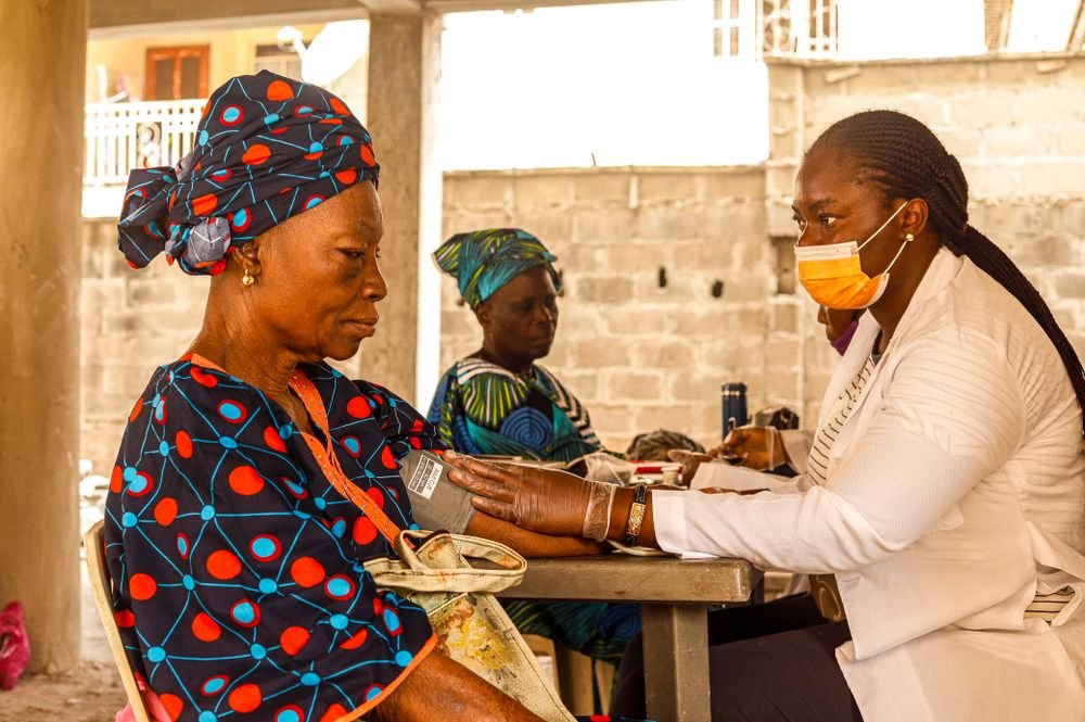 A health worker checking a woman's blood pressure