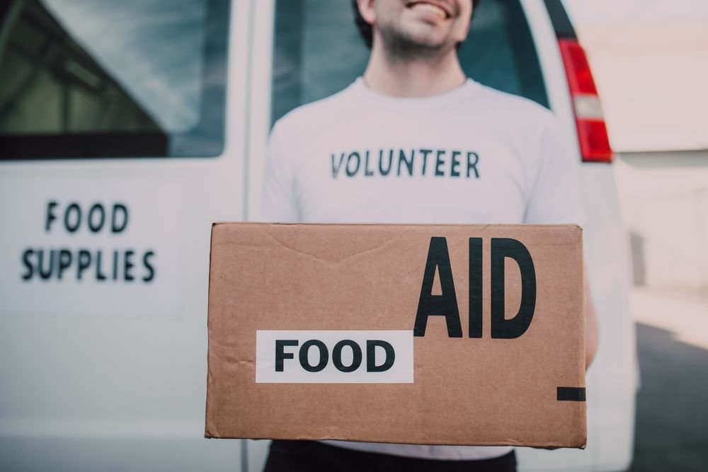 Volunteer carrying a food aid box