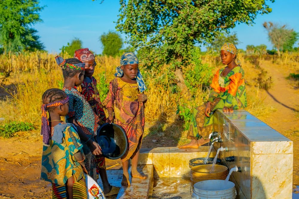 Children gathered at an outdoor water tap