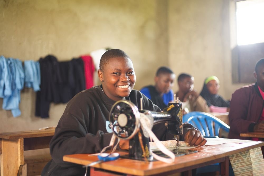 Students learning on sewing machines in class