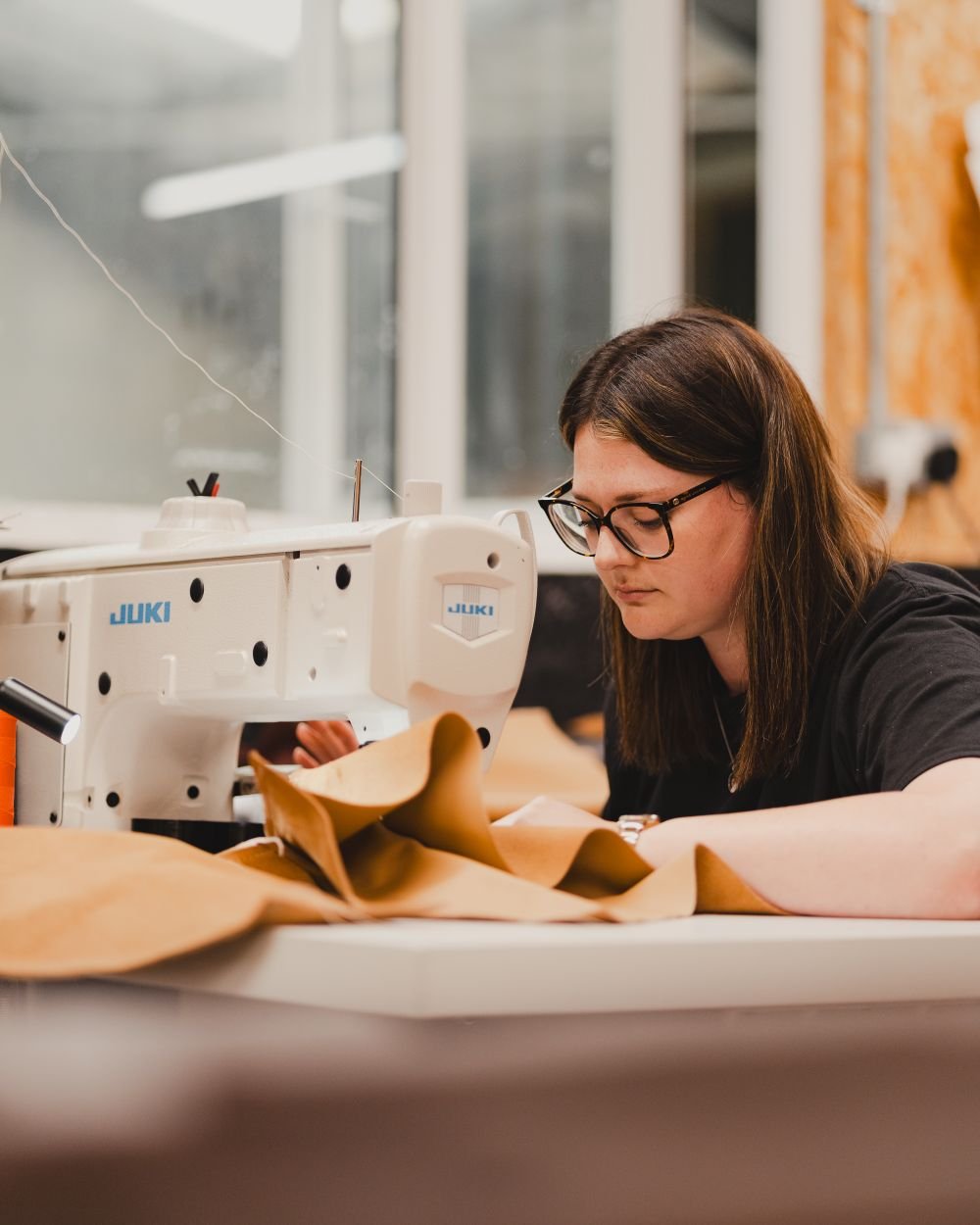 A woman working at a sewing machine in a workshop